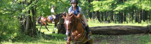 Jeune cavalière faisant du cross-country durant son séjour au camp équestre, New York, USA