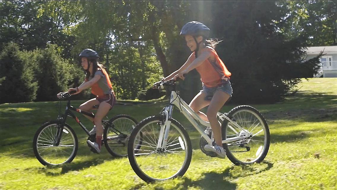 Jeunes adolescentes sur un vélo lors d'un summer camp