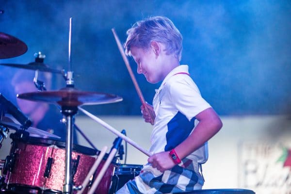 enfant jouant de la batterie lors de son séjour en summer camp aux USA