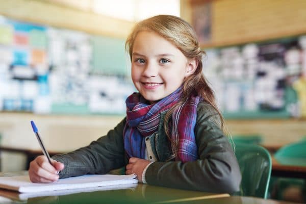 Jeune enfant souriante durant un cours de langue en séjour linguistique