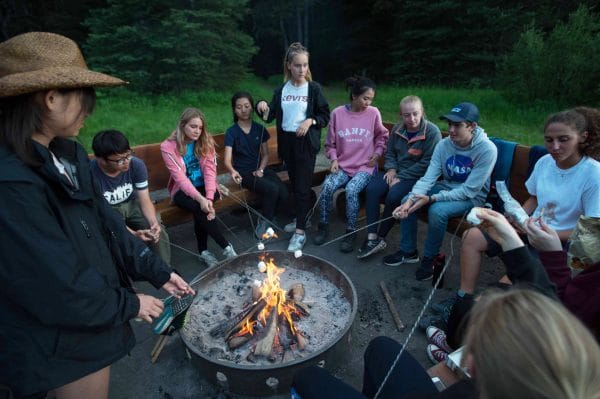 Jeunes autour d'un feu de camp durant leur summer camp au Canada