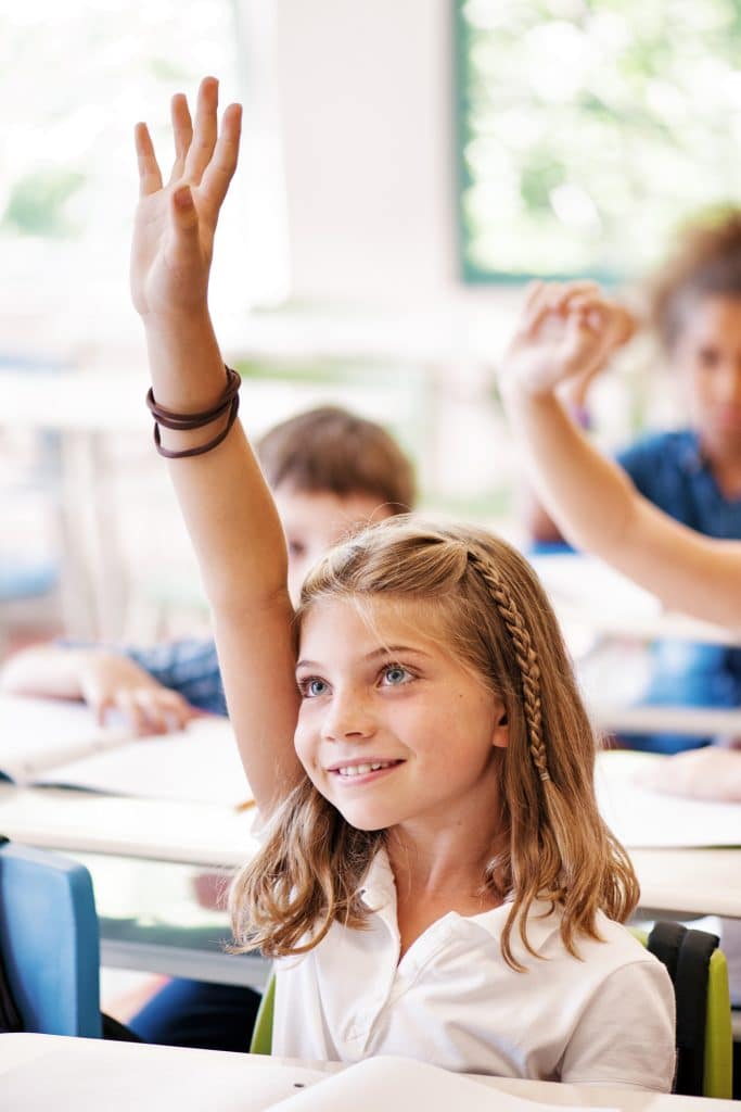 Petite fille qui lève la main en cours d'anglais