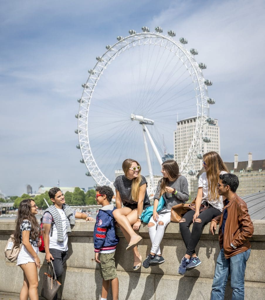 Adolescents assis sur un pont devant London Eye à Londres durant leur séjour linguistique pour adolescents en Angleterre