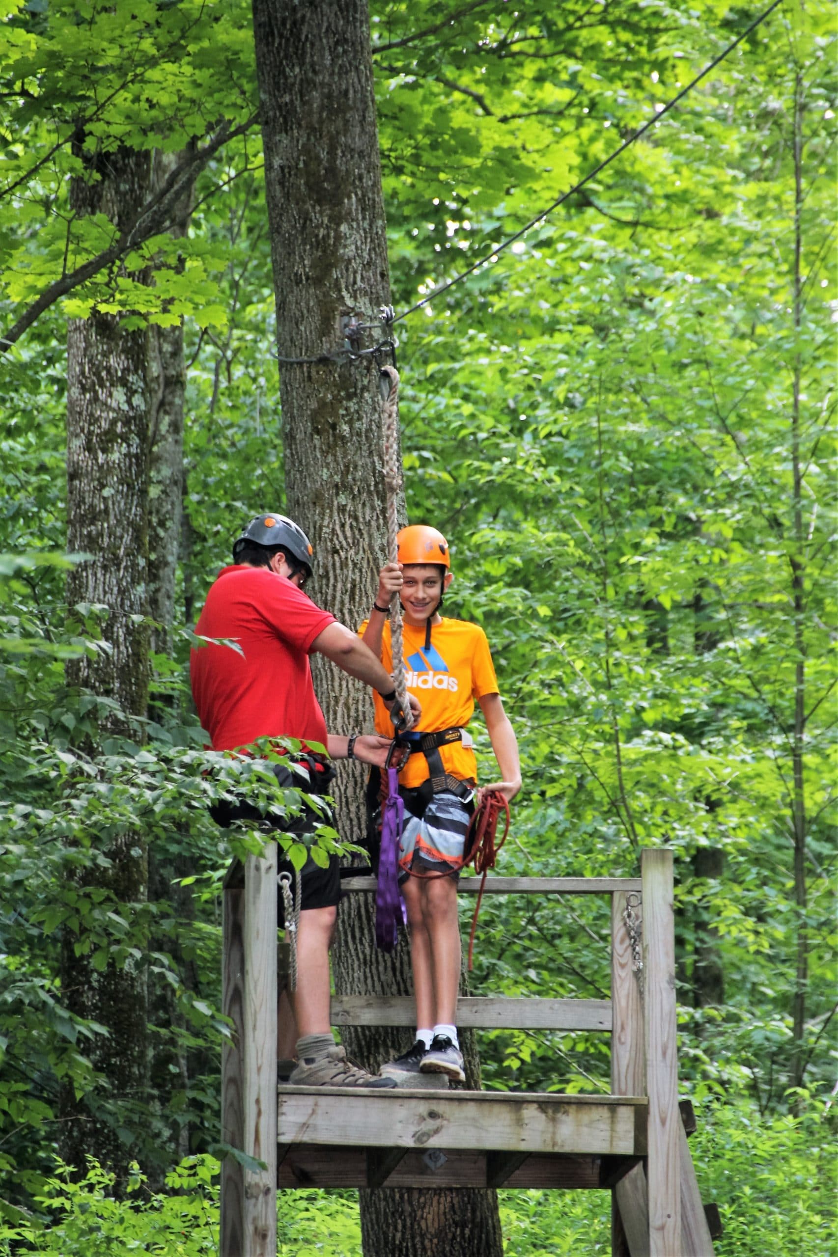 Jeune garçon et moniteur durant une activité accrobranche en summer camps aux USA