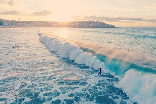 Plage au coucher de soleil avec des surfeurs sur les vagues