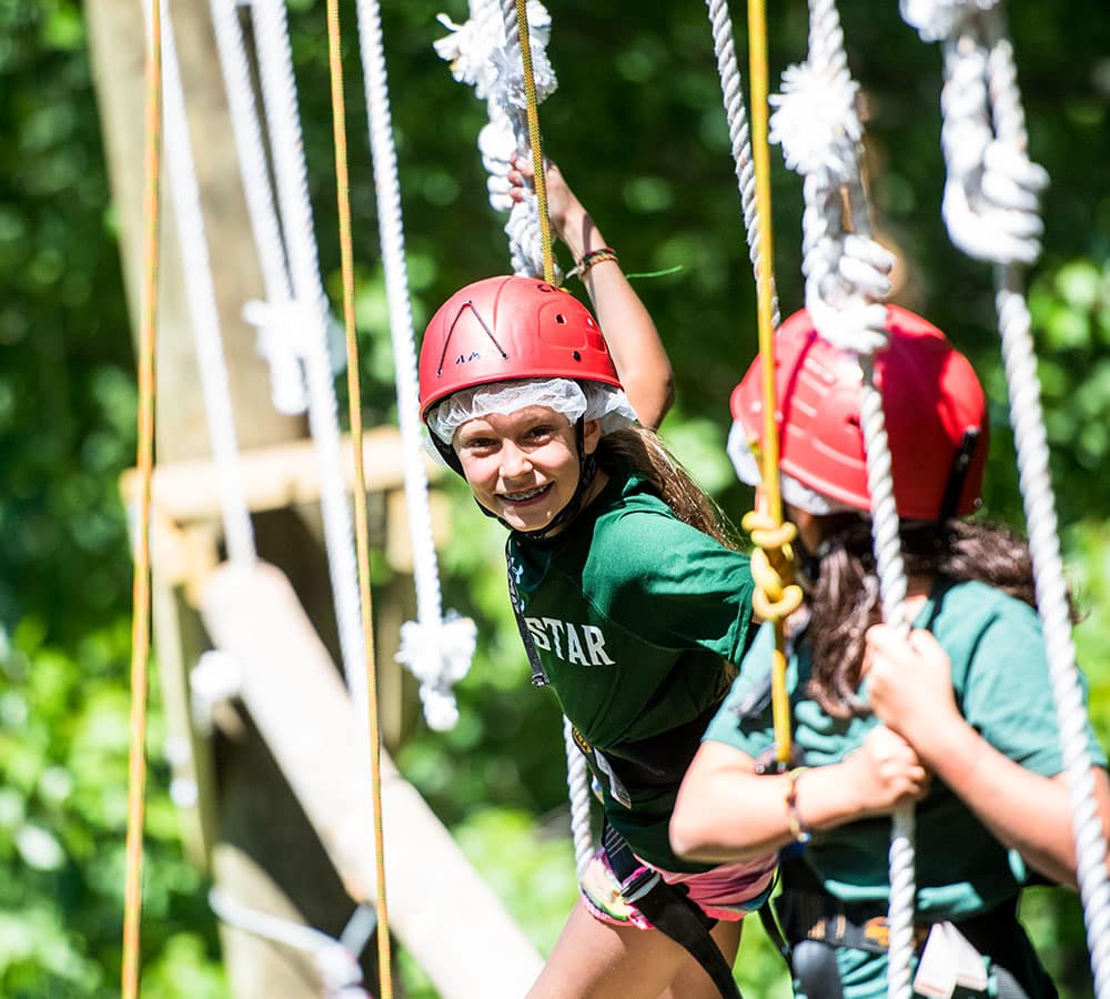 enfants évoluant sur le parcours de cordes en hauteur durant leur summer camp