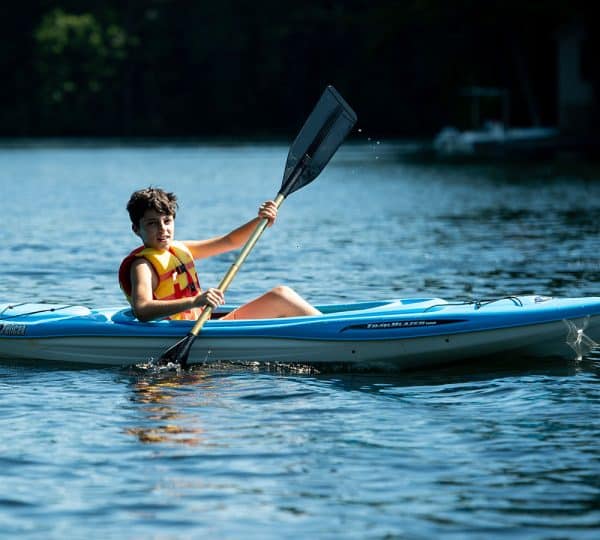 jeune garçon en canoë durant son summer camp dans le Maine aux USA